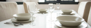 Gedeckter Tisch mit Porzellangeschirr und edlen Gläsern